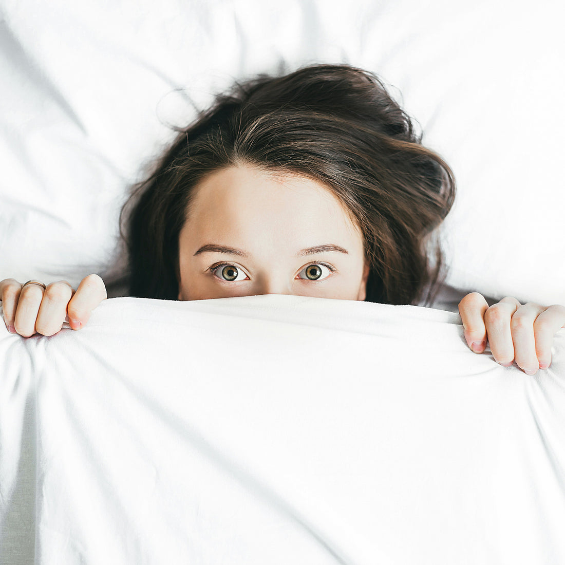 C'est une personne sous une couverture, on ne voit que le haut de sa tête qui sort de du lit